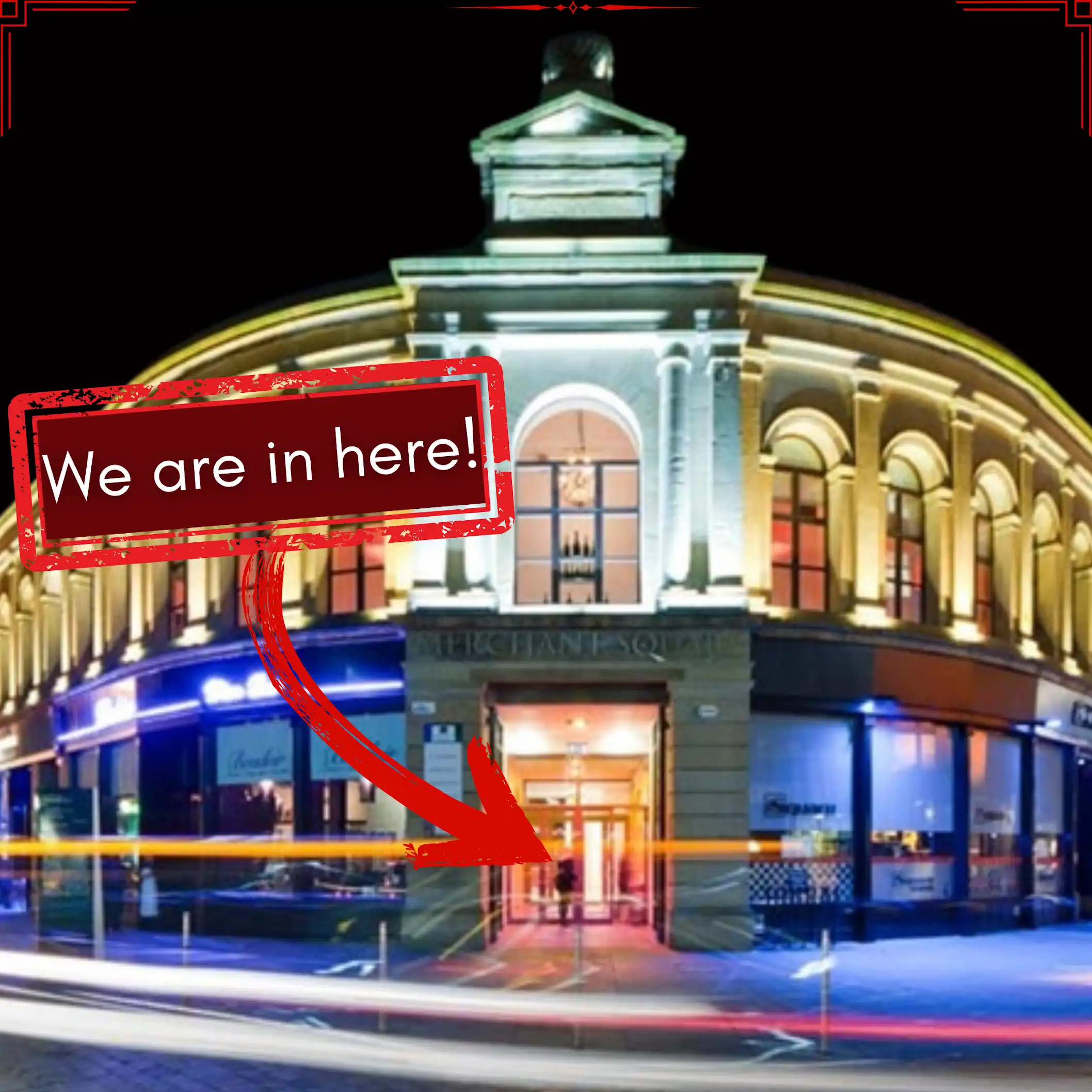 Merchant Square building at night with an arrow pointing to the Nomad Escape entrance